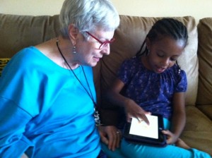 My granddaughter, Aster, showing me how she uses the Kindle, summer 2013.